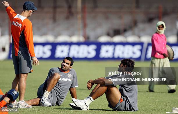 Indian cricketer Mahendra Singh Dhoni looks on as coach Gary Kirsten speaks to Zaheer Khan and Munaf Patel during a training session ahead of the...