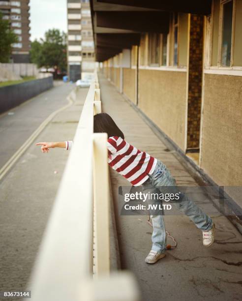 girl pointing through railings on housing estate  - london child foto e immagini stock