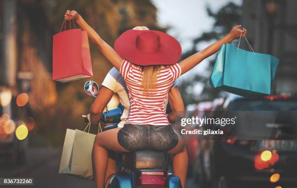 couple on a scooter coming back from shopping. - coming back stock pictures, royalty-free photos & images