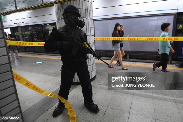 South Korean armed policeman takes part in an anti-terror drill at a subway station in Seoul on August 22 on the sidelines of a South Korea-US joint...