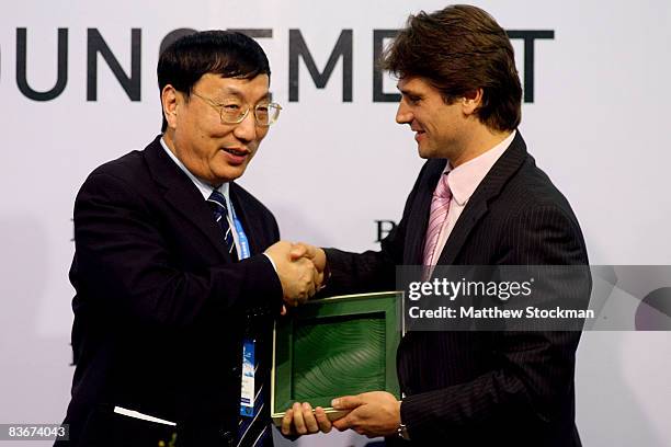 Qiu Weichang, Deputy Director of Shanghai Administration of Sports, accepts a gift from Arnaud Boetsch of Rolex at a press conference to announce...