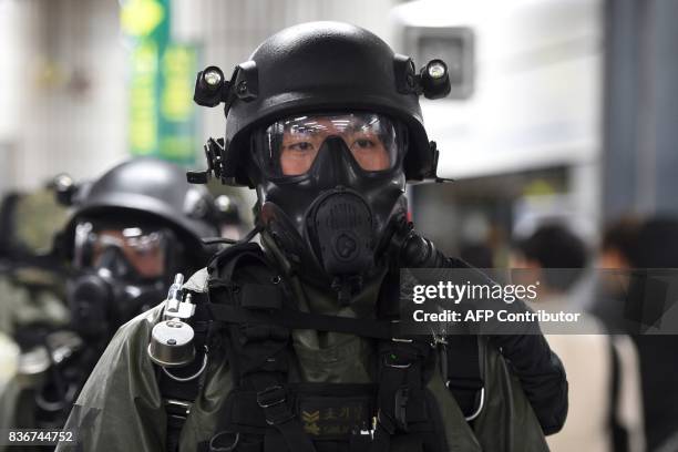 South Korean soldiers wearing chemical protective suits take part in an anti-terror drill at a subway station in Seoul on August 22 on the sidelines...