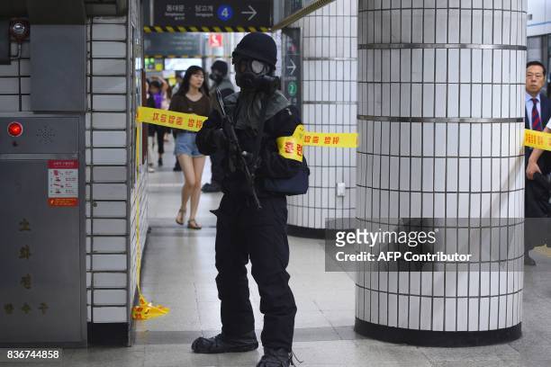 South Korean armed policeman takes part in an anti-terror drill at a subway station in Seoul on August 22 on the sidelines of a South Korea-US joint...