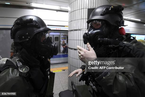 South Korean soldiers wearing chemical protective suits take part in an anti-terror drill at a subway station in Seoul on August 22 on the sidelines...