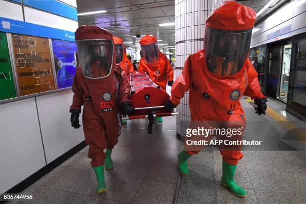 South Korean rescue members wearing chemical protective suits take part in an anti-terror drill at a subway station in Seoul on August 22 on the...