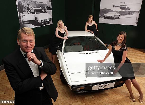 Staff from Bonhams auctioneers dressed as characters from a James Bond film pose with the white 1976 Lotus Esprit car from the 1977 film ' The Spy...