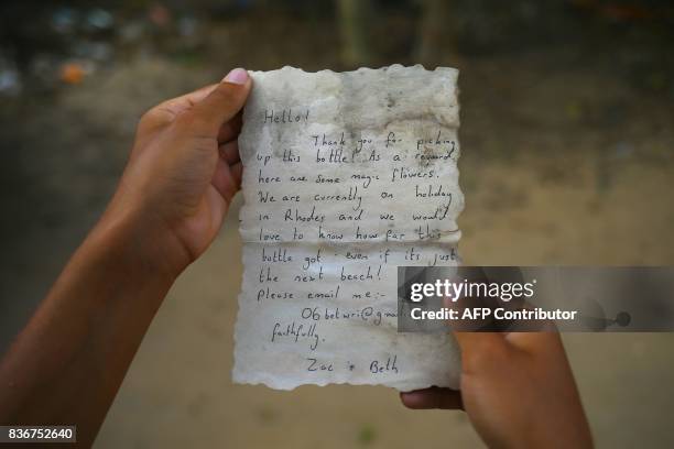 Picture shows the message Palestinian fisherman Jihad al-Soltan found in a bottle off a Gaza beach after it was placed in the water last July by two...