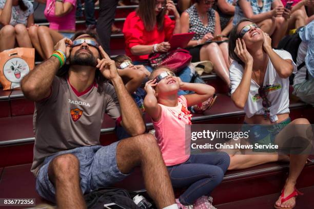 People gather at Times Square to view the solar eclipse on August 21, 2017 in New York City, United States.