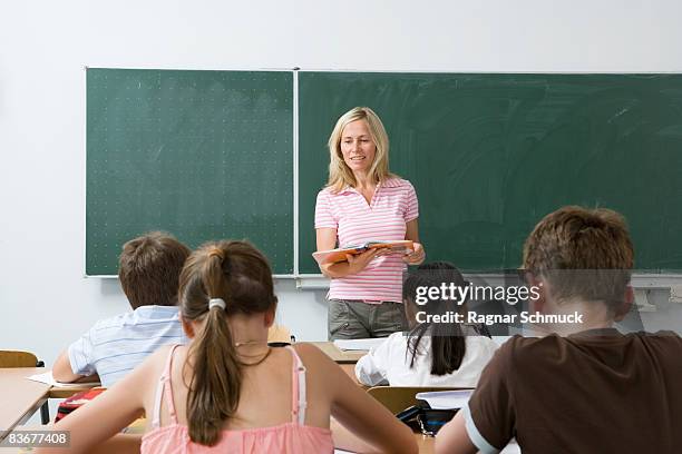 teacher in front of her class - schultafel stock-fotos und bilder