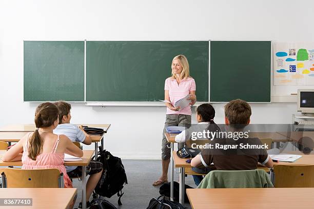 teacher in front of her class - schultafel stock-fotos und bilder