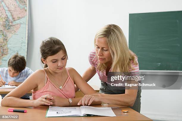 a teacher helping a student in a classroom - girl in tank top stock pictures, royalty-free photos & images