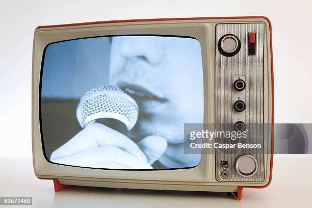 a television with a black and white image of a person singing into a microphone - vintage tv stock-fotos und bilder