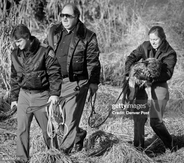 Denver Animal Control officers David Peachey, Curtis Bradley and Sheeri Dunn with stray dog that fell through the ice in Barnum Park Lake Wednesday...