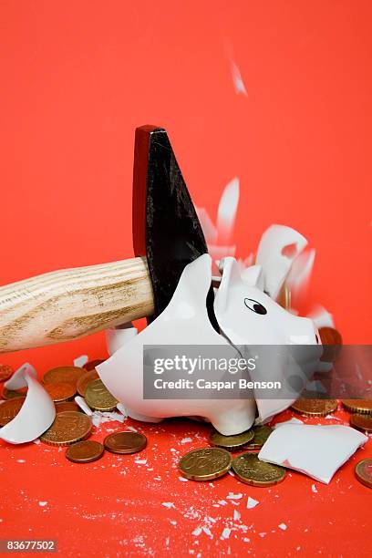 a hammer smashing a piggy bank - smashed piggy bank stock pictures, royalty-free photos & images