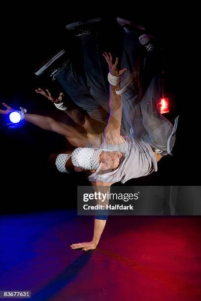 a b-boy doing a pike freeze breakdance move - stage light black background stock pictures, royalty-free photos & images