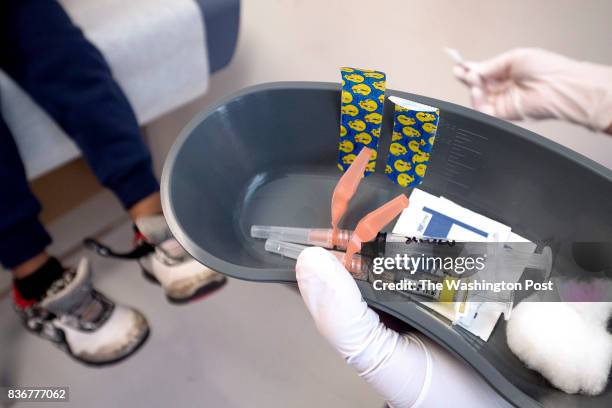 Nurse Lydia Fulton prepares to administer the measles, mumps, and rubella vaccine as well as a vaccine used to help prevent the diseases of...