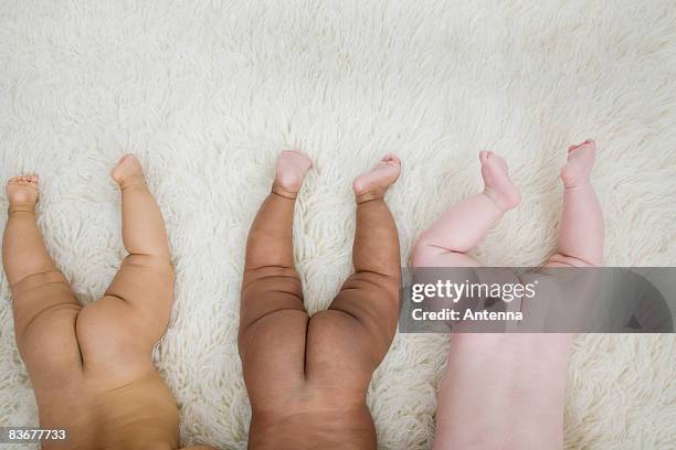 three babies bare bottoms in a row - baby bottom stock pictures, royalty-free photos & images