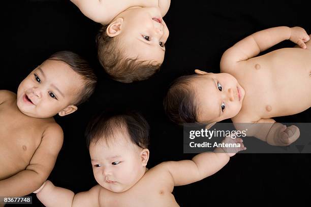 four babies lying in a circle, directly above - eye color stock pictures, royalty-free photos & images