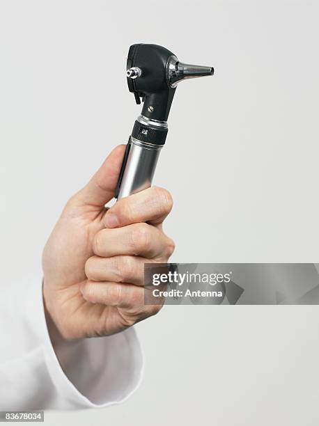 human hand holding an otoscope - otoscope bildbanksfoton och bilder