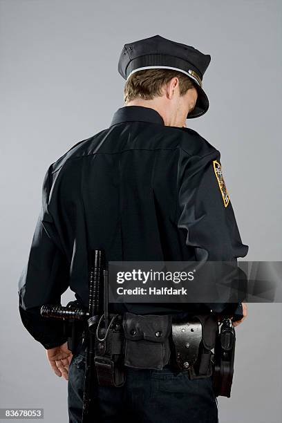 rear view of a police officer - uniforme della polizia foto e immagini stock