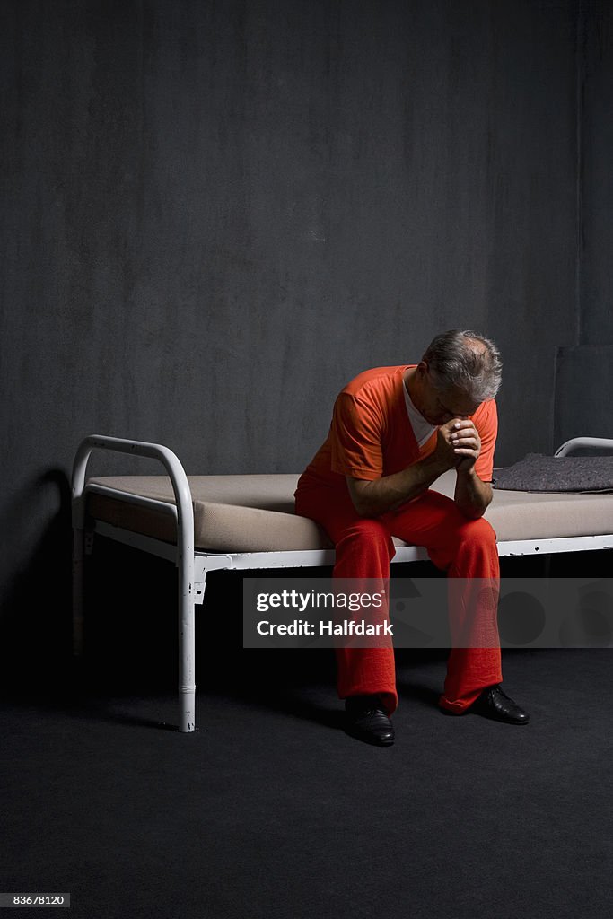 A prisoner sitting in his prison cell