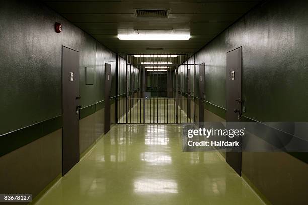 an empty prison corridor - gefängnis stock-fotos und bilder