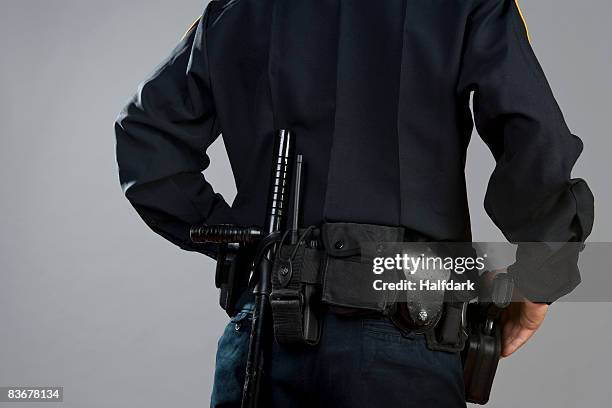 rear view of a police officer carrying weapons - black police stock pictures, royalty-free photos & images