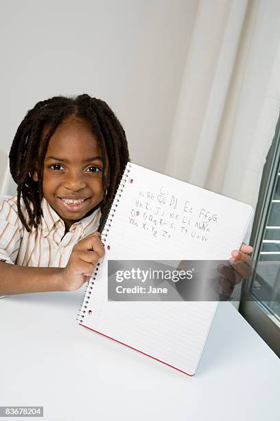 a young boy showing his homework - alphabetical order stock pictures, royalty-free photos & images