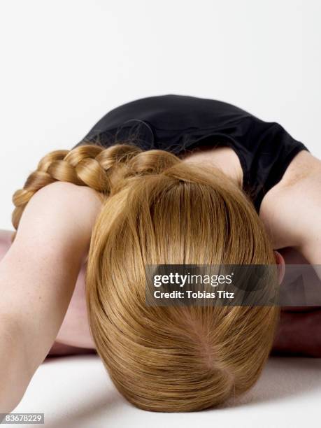 a young woman bending over and resting her head on the floor - parte superior de la cabeza fotografías e imágenes de stock