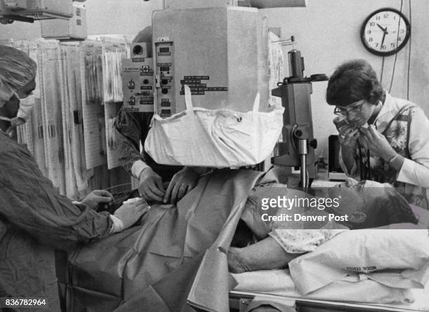 Dr. David Kumpe, Hidden By Fluoroscope, Inserts Balloon Catheter Into Iliac Artery Procedure was on Curtis Davis' left leg to reduce partial artery...