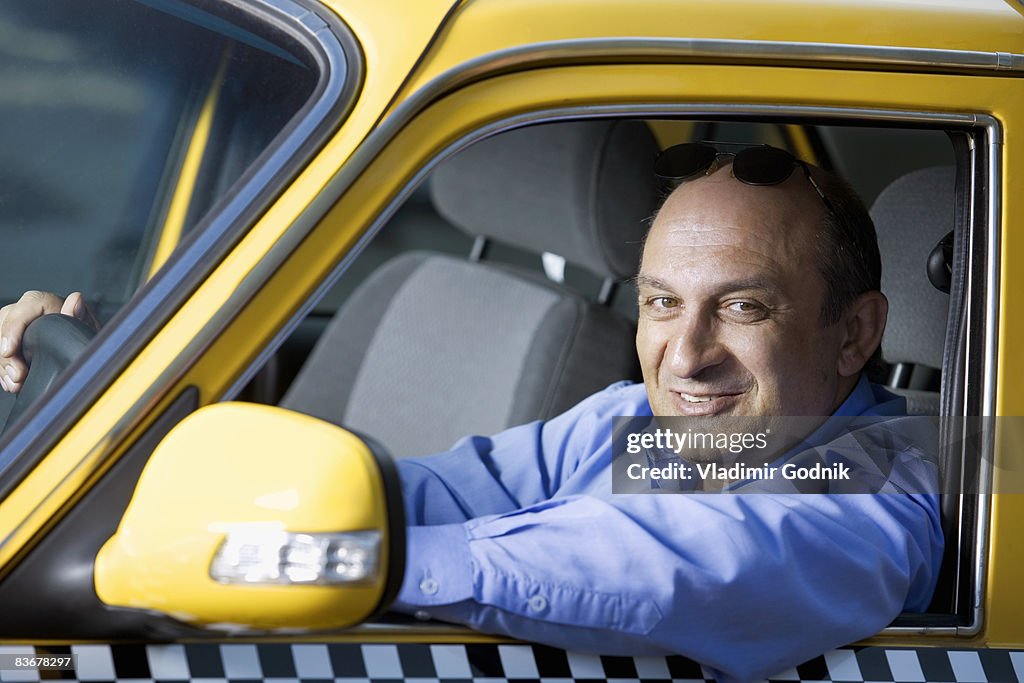 A taxi driver sitting in his car