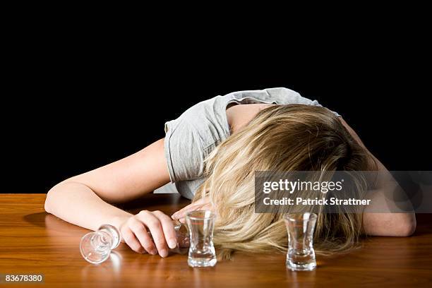 a young woman passed out drunk on a bar counter - passed out drunk stockfoto's en -beelden