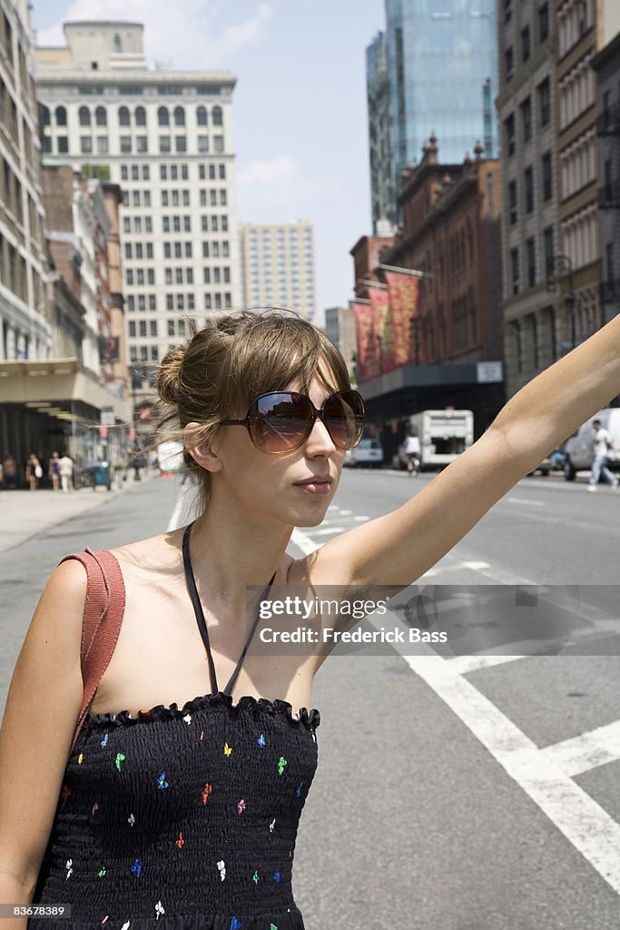 A young woman hailing a taxi, Brooklyn, New York