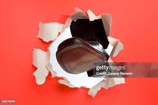 a foot kicking through a wall - breaking through wall stockfoto's en -beelden