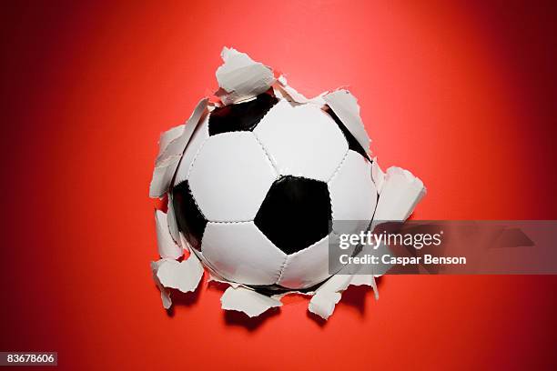 a football break through a wall - breaking through wall stockfoto's en -beelden
