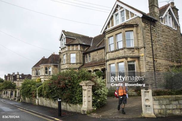 Postman delivers letters to a home on a suburban street in Bath, U.K. On Monday, Aug. 21, 2017. U.K. Property prices stagnated in July as a slump in...