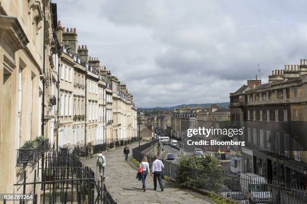 Pedestrians walk past a row of terraced houses on a suburban street in Bath, U.K. On Monday, Aug. 21, 2017. U.K. Property prices stagnated in July as...