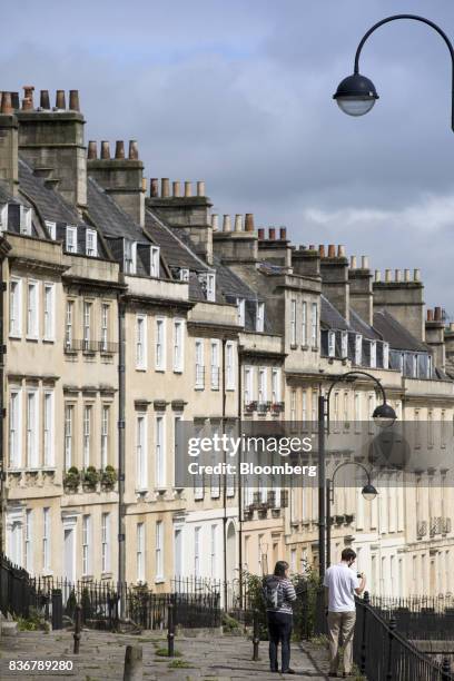 Pedestrians walk past a row of terraced houses on a suburban street in Bath, U.K. On Monday, Aug. 21, 2017. U.K. Property prices stagnated in July as...