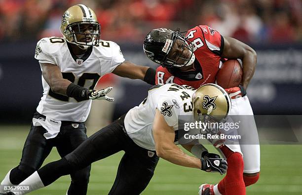 Roddy White of the Atlanta Falcons is brought down by Kevin Kaesviharn of the New Orleans Saints at Georgia Dome on November 9, 2008 in Atlanta,...