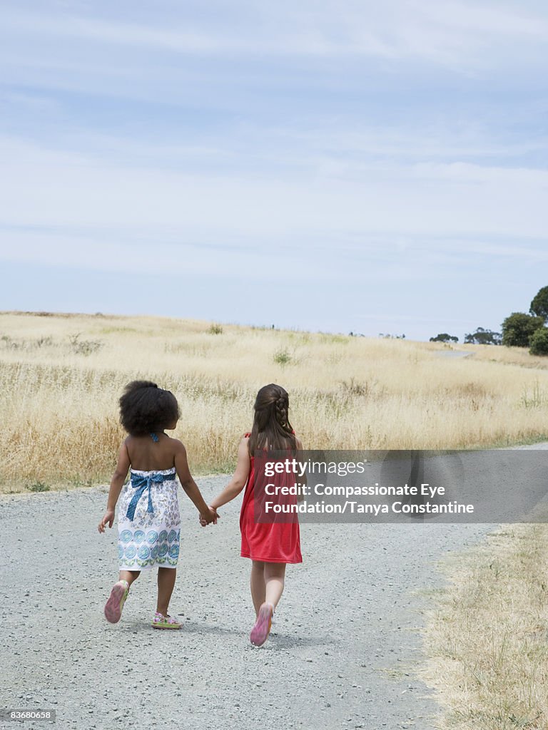 Two little girls walking down the road