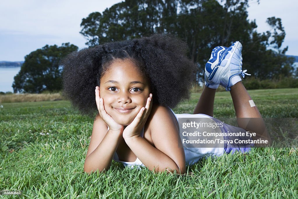Little girl laying on grass