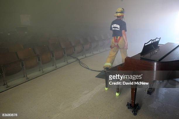Firefighter walks through a simulated smoke-filled burning school auditorium as students of Stevenson Elementary School participate in the...