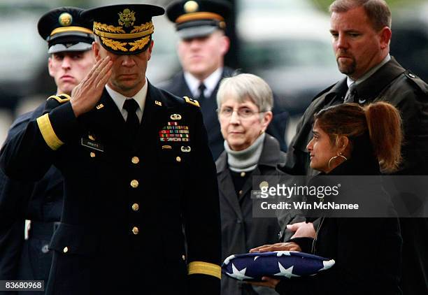 Rashmi Grieco , widow of Staff Sgt. Kevin D. Greico, holds an American flag presented by Brig. Gen. Robert Platt during burial services at Arlington...