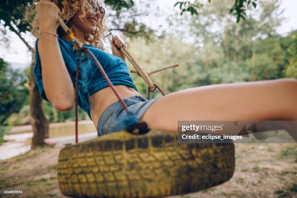 Jeune fille se balançant sur traktor pneu