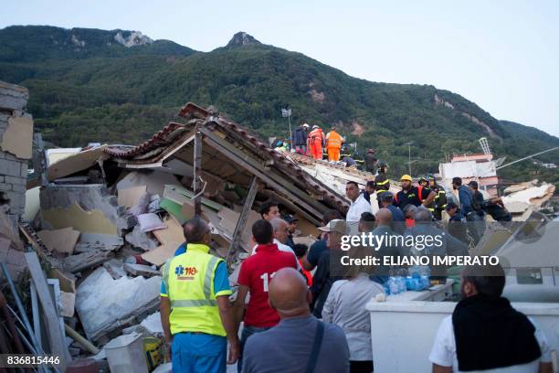 Italian firemen and emergency workers search through rubble of a collapsed house in Ischia, on August 22 after an earthquake hit the popular Italian...