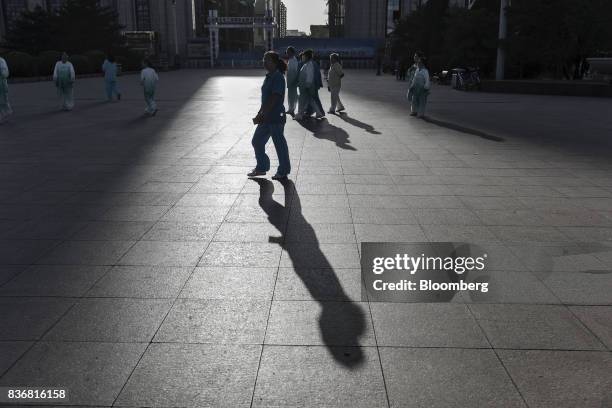 Pedestrians walk through the main square in Baotou, Inner Mongolia, China, on Friday, Aug. 11, 2017. China's economy showed further signs of entering...