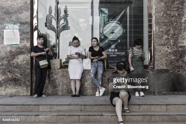 Workers wait for the doors of a department store to open in Baotou, Inner Mongolia, China, on Friday, Aug. 11, 2017. China's economy showed further...