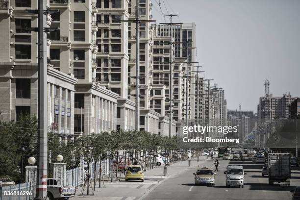 Vehicles travel past new residential buildings in Baotou, Inner Mongolia, China, on Friday, Aug. 11, 2017. China's economy showed further signs of...