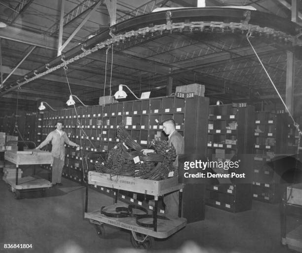 The Parts Train-A continuous chain pulls small. Cars around the main parts stockpile at International harvester's new parts depot in Denver. Orders...