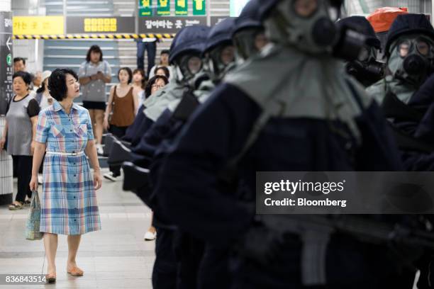 Bystander looks on as police officers wearing gas masks take part in an anti-terror drill on the sidelines of the Ulchi Freedom Guardian military...